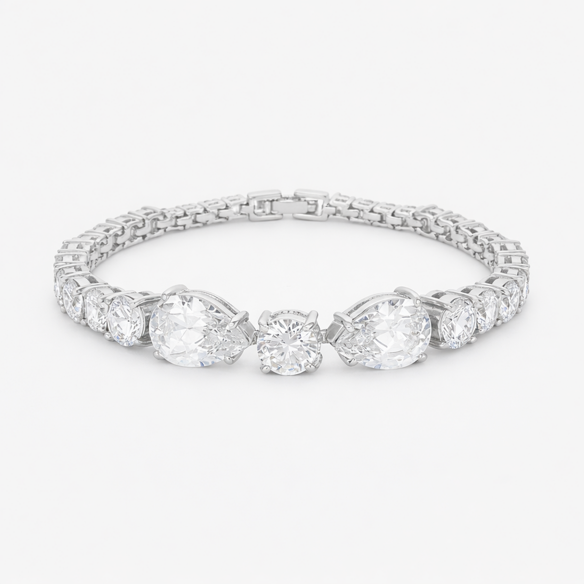 Studio view of a tennis bracelet featuring pear and round cut cubic zirconia set in rhodium plated brass.