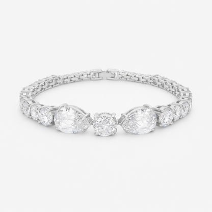 Studio view of a tennis bracelet featuring pear and round cut cubic zirconia set in rhodium plated brass.