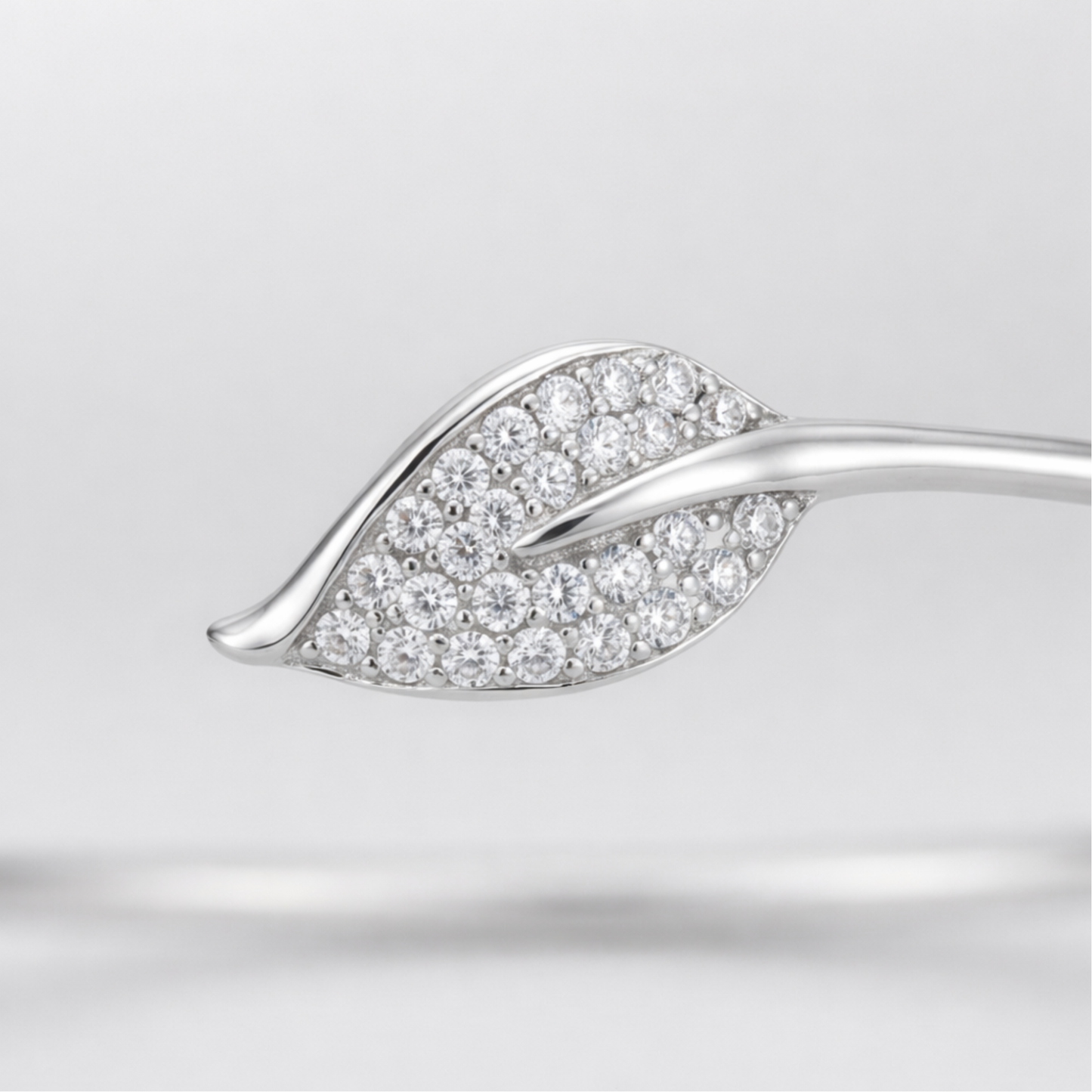 Close up view of the open cuff bracelet showing smooth curves and cubic zirconia detailing.