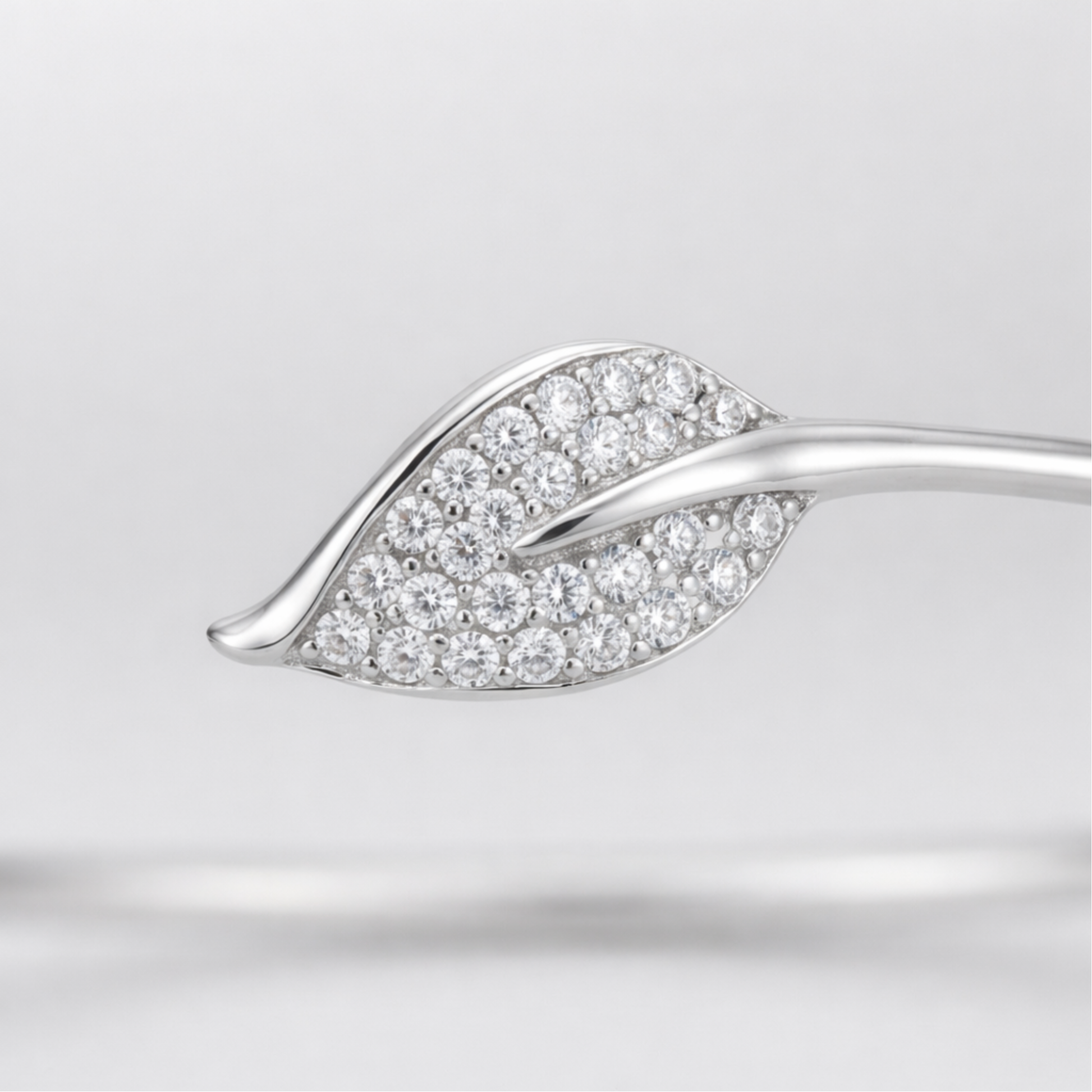 Close up view of the open cuff bracelet showing smooth curves and cubic zirconia detailing.