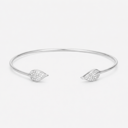 Front view of an open silver tone cuff bracelet featuring a smooth polished surface and cubic zirconia accents on both ends.